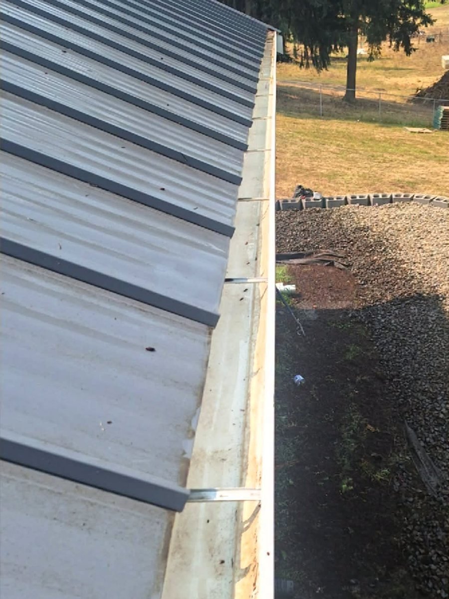 The same gutter run after cleaning, clear metal all the way down